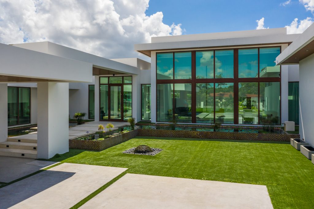 modern home with striking architecture, featuring large glass windows framed in rich wood