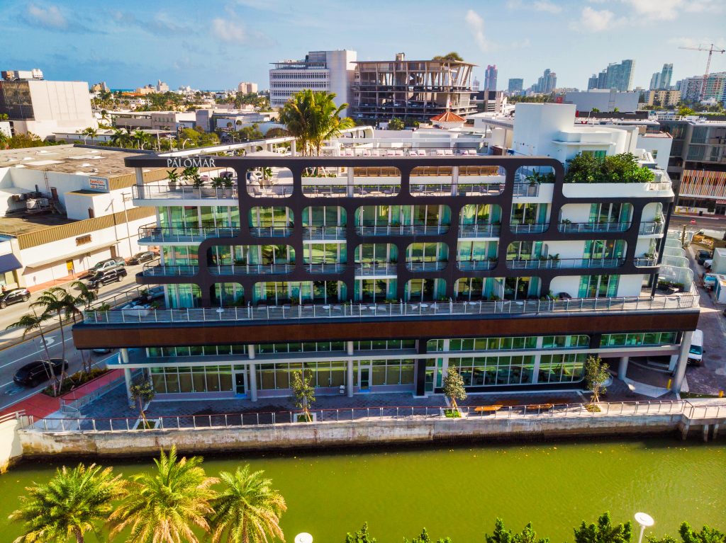 modern structure with a unique facade featuring rounded rectangular cutouts that frame glass-fronted balconies