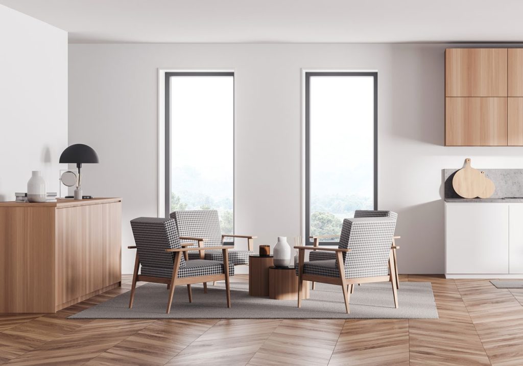 minimalist living space with two modern armchairs and a small round table on a neutral rug